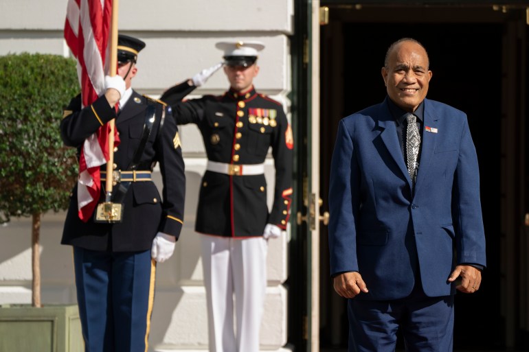 Kiribati President Taneti Maamau at the White House. There are ceremonial guards at his right shoulder. He is smiling.