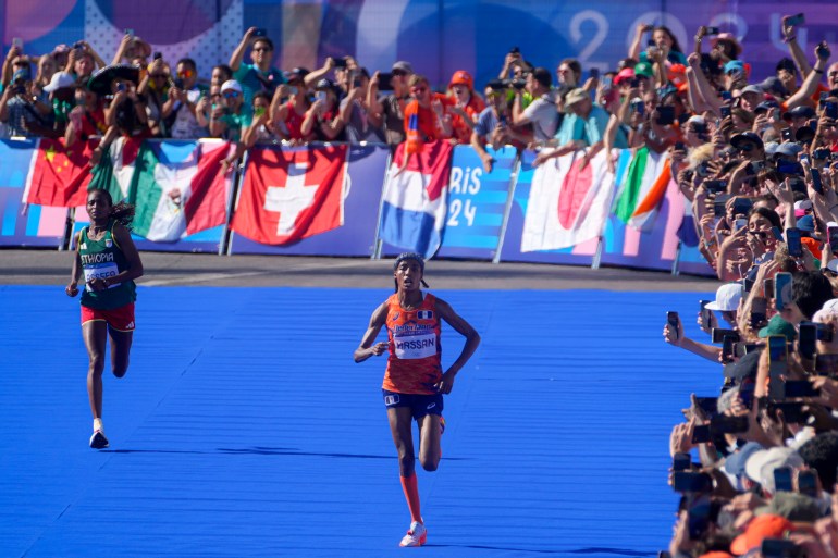 Sifan Hassan, of the Netherlands, right, and Ethiopia's Tigst Assefa, left, approach the finish line at the end of the women's marathon competition at the 2024 Summer Olympics, Sunday, Aug. 11, 2024, in Paris, France. (AP Photo/Dar Yasin)