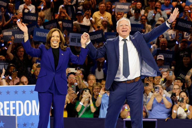 Kamala Harris and Tim Walz raise their hands in celebration during a rally in Milwaukee