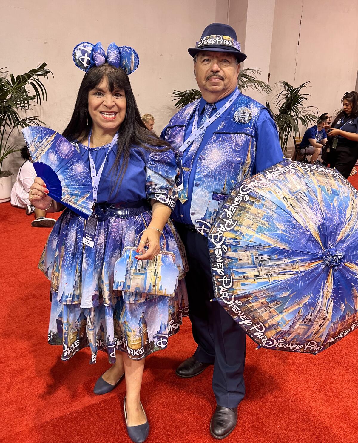 Two fans wear handmade costumes made of recycled Disney parks bags.