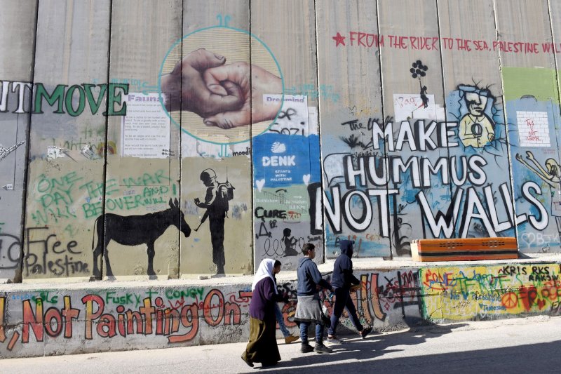 A work titled "Scar of Bethlehem" by graffiti artist Banksy shows a nativity scene in front of the Israeli separation barrier, is displayed on December 23, 2019. Workers removed his latest work, a black cat, from a north London billboard Saturday. Photo by Debbie Hill/UPI