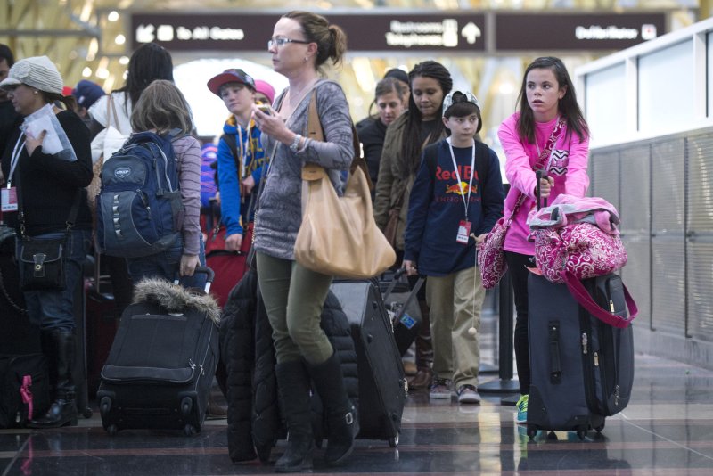 Travelers wait in check-in at the airline at Ronald Reagan National Airport, November 26, 2013, in Arlington, Virginia. The Biden administration proposed a new rule to ban extra fees airlines charge for families to sit together. File Photo by Kevin Dietsch/UPI