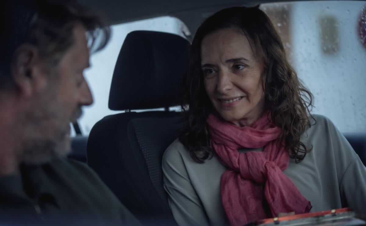 A woman smiles in a car.