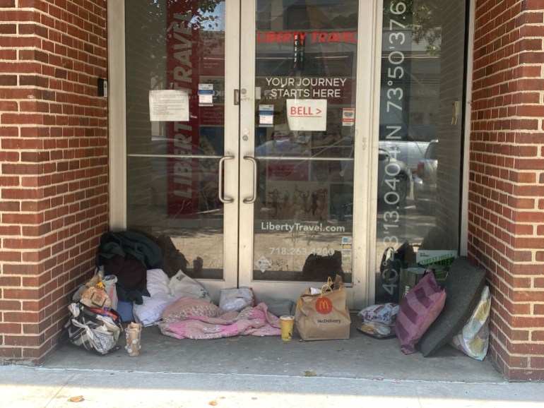 Homeless encampment in doorway of closed business,