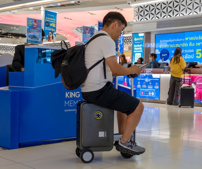 Passengers using smart electric suitcases at Bangkok airport, Thailand. (Photo by: Bob Henry/UCG/Universal Images Group via Getty Images)