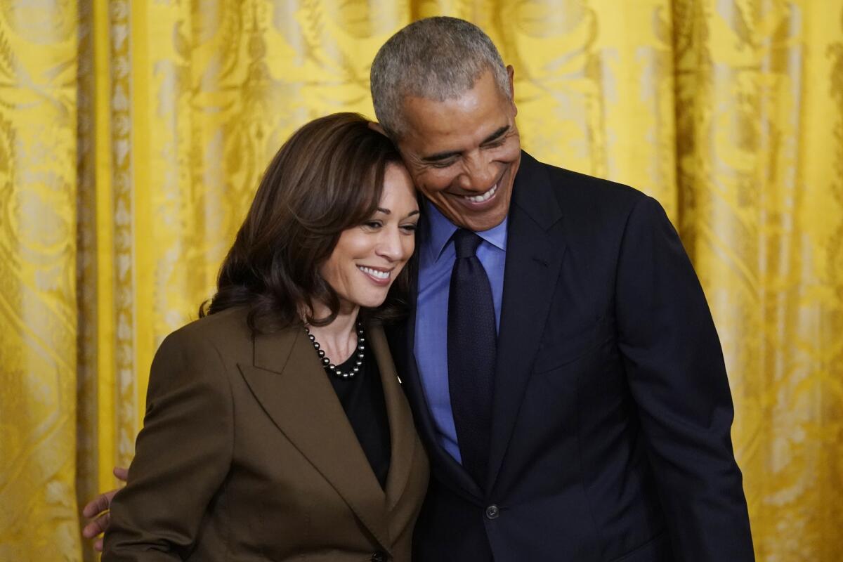 Vice President Kamala Harris and former President Obama lean together onstage.