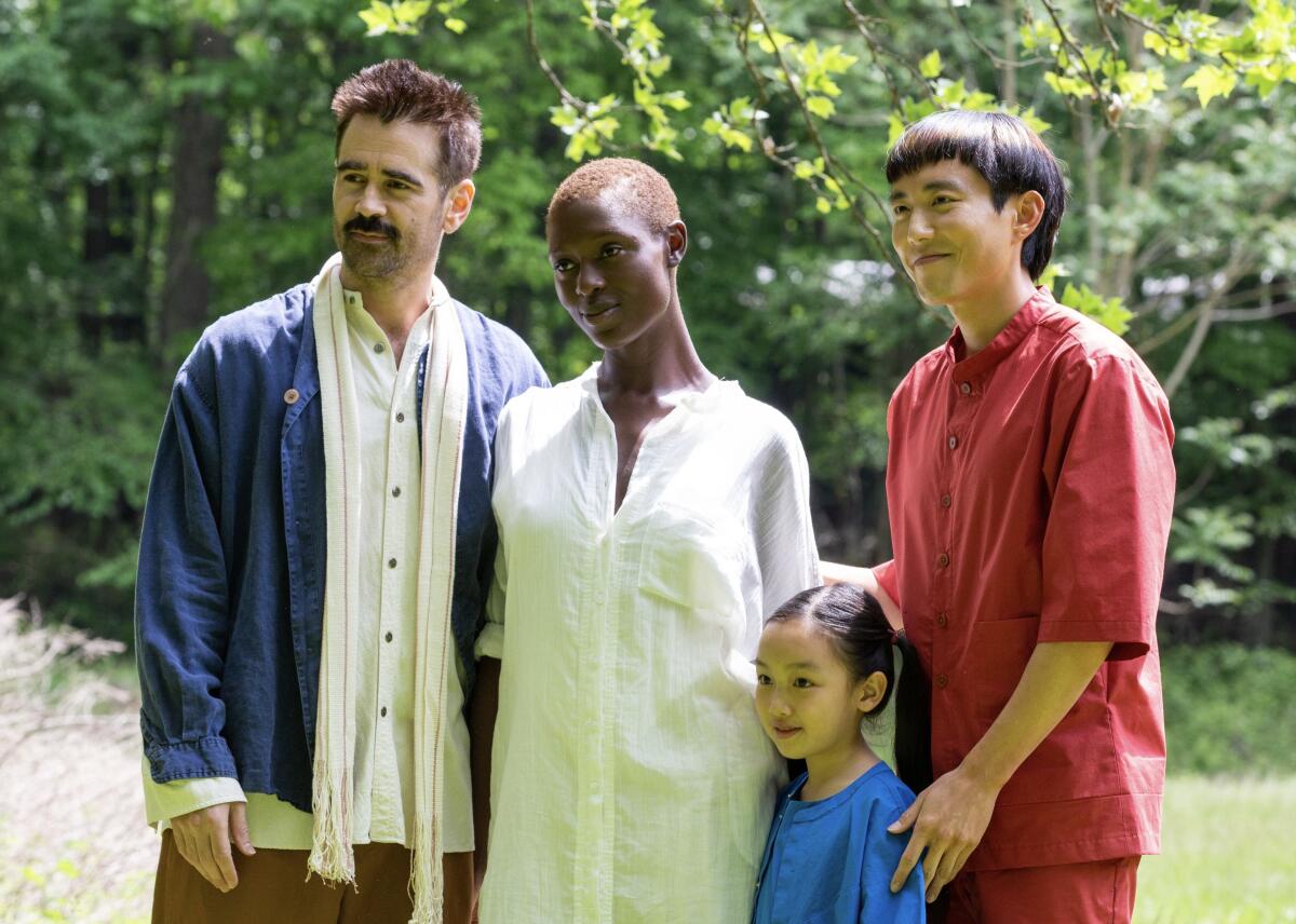 A racially mixed family poses for a photo in a movie.