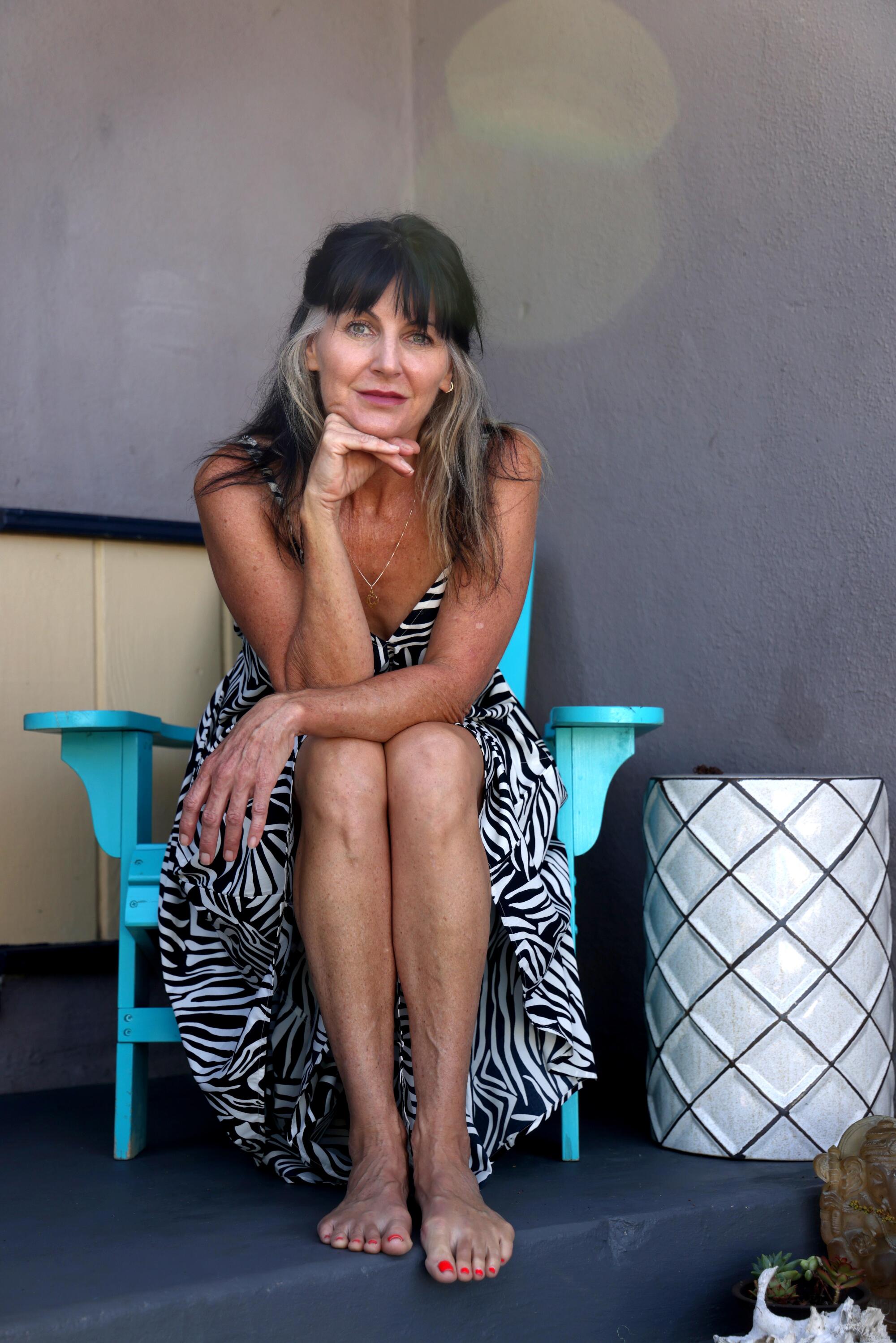 Set decorator Cheryl Murphy sits on the front porch of her home