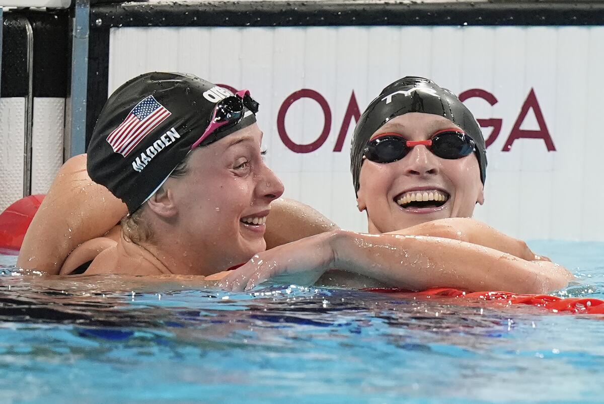 two women wearing U.S. swim caps in a pool