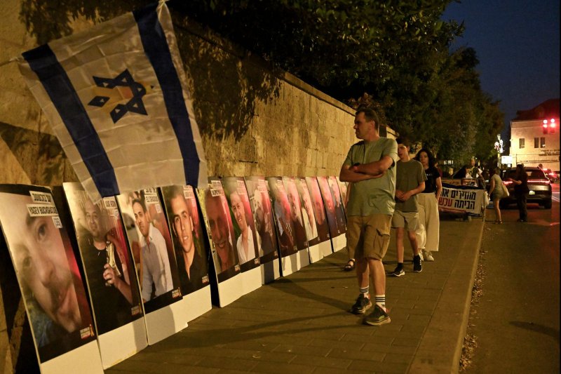 People look at posters of Israeli hostages on the street outside Prime Minister Benjamin Netanyahu's residence in Jerusalem, on June 8. The Israel Defense Forces on Wednesday announced that it had retrieved the body of a soldier who was killed Oct. 7 and taken into Gaza. File Photo by Debbie Hill/ UPI