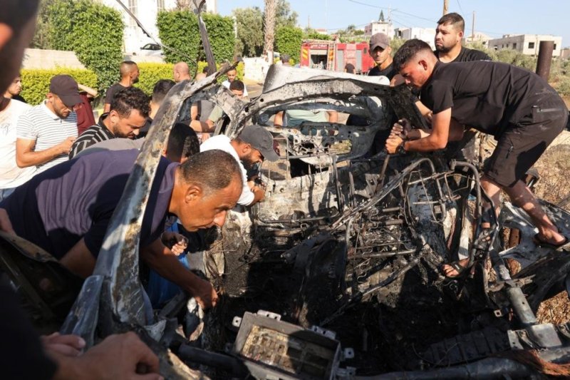 Palestinians in the West Bank examine the remains of a vehicle struck by Israel Defense Forces that the IDF said was carrying five Hamas militants to a location where they planned to carry out an attack. Photo by Alaa Badarneh/EPA-EFE