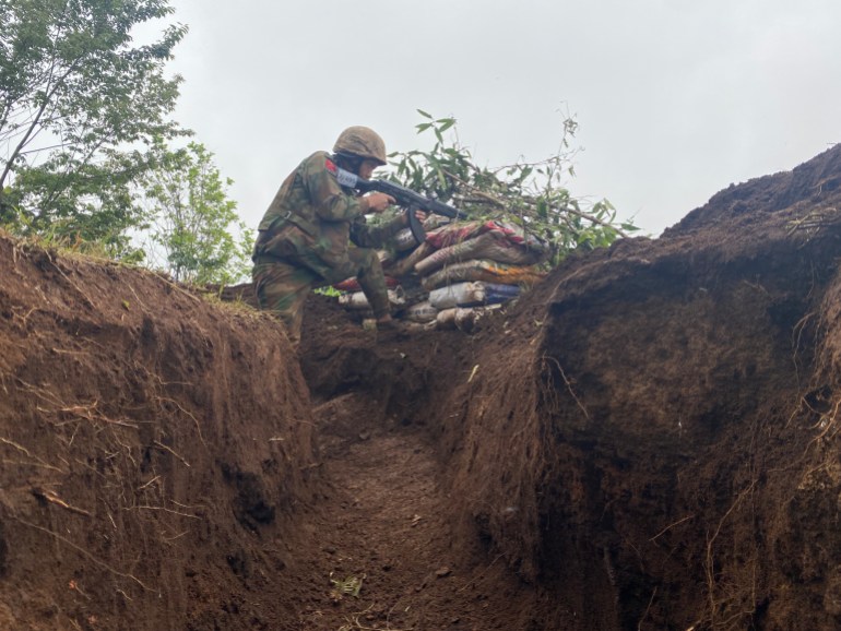 A soldier in a trench. He is about to fire his weapon.