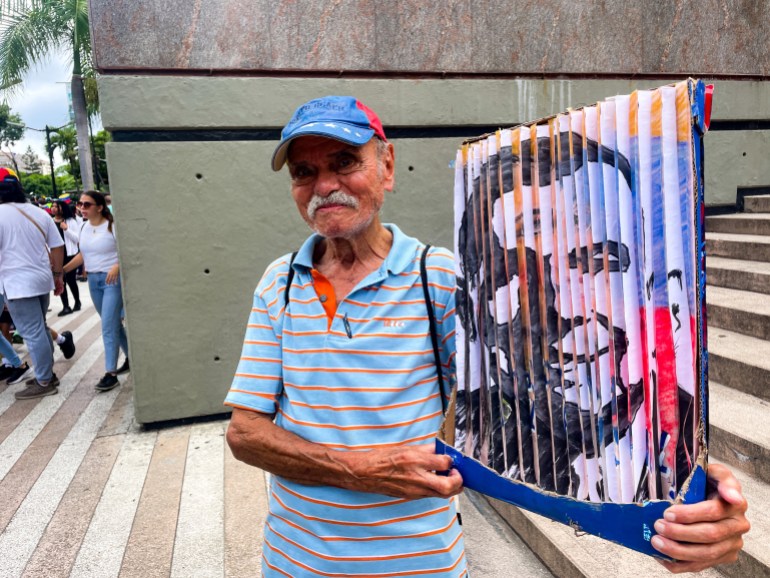 Jorge Fermin holds up a handmade poster of Edmundo Gonzalez