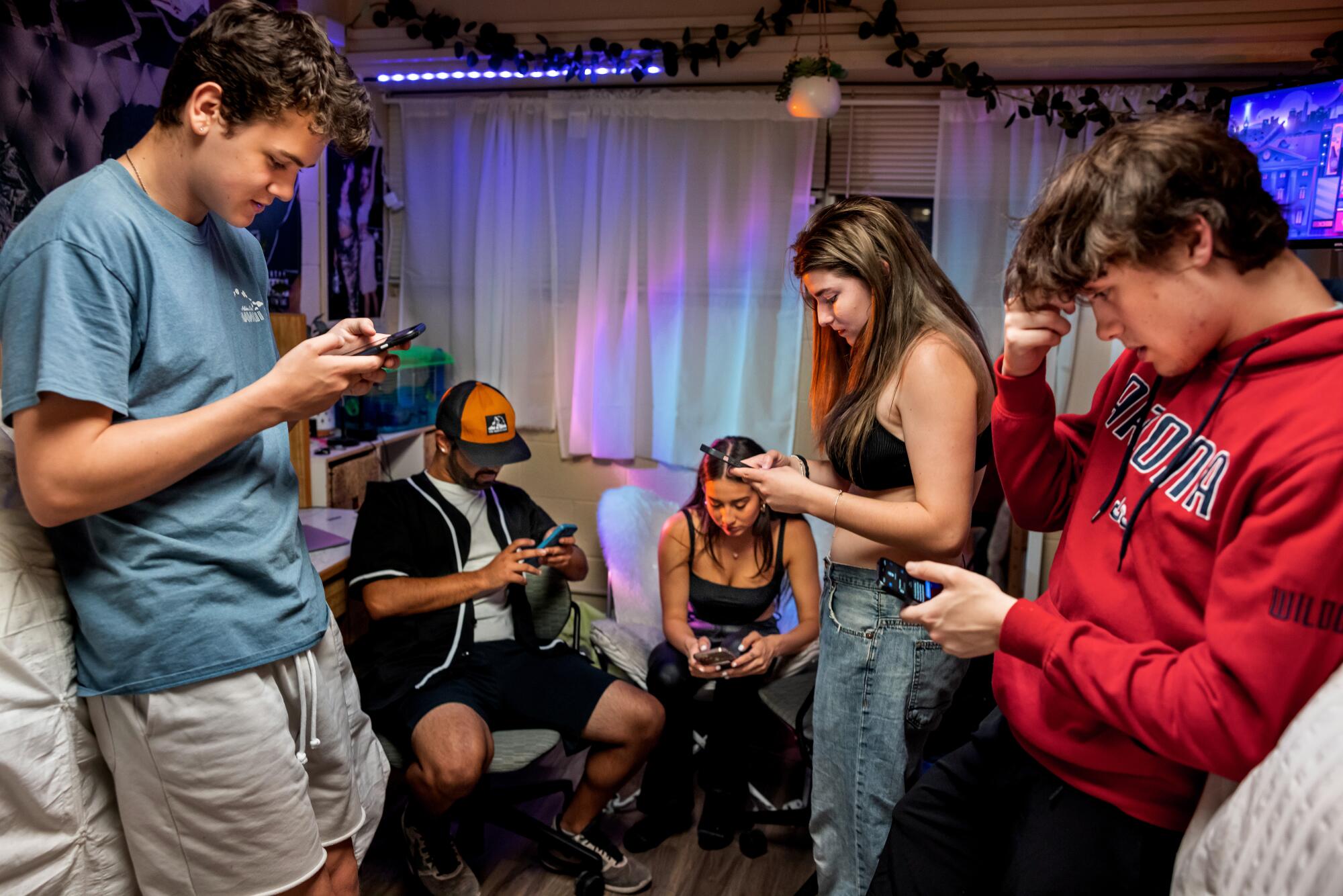 A group of young people looking at their phones