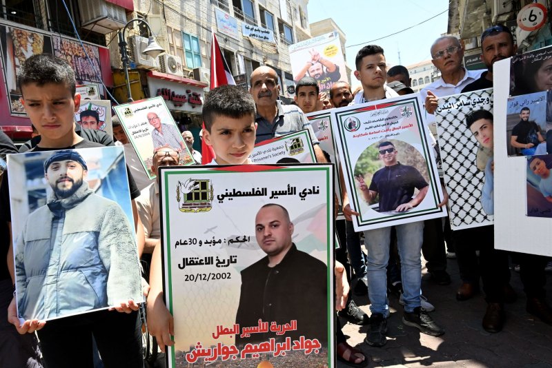 Palestinians hold posters with photos of prisoners at a protest on International Day of Solidarity with Gaza and Palestinian Prisoners in Bethlehem, West Bank, on Saturday. Photo by Debbie Hill/ UPI