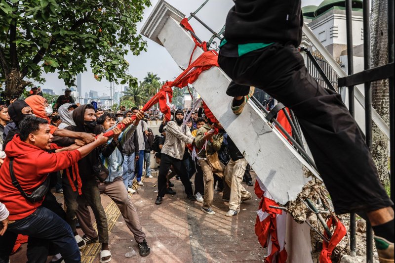 Protesters tear down the gate of Indonesia's parliament building in Jakarta on Thursday in a protest over the government's attempt to reverse constitutional court reforms to election laws. Photo by Mast Irham/EPA-EFE