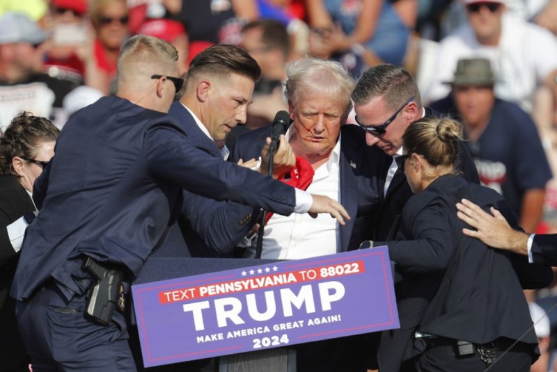 Former President Donald Trump is rushed off the stage by Secret Service agents after an assassination attempt during a campaign rally in Butler, Pa., on July 13. Several agents have been placed on administrative leave in connection with a probe of the incident, according to multiple reports on Friday. File Photo by David Maxwell/EPA-EFE