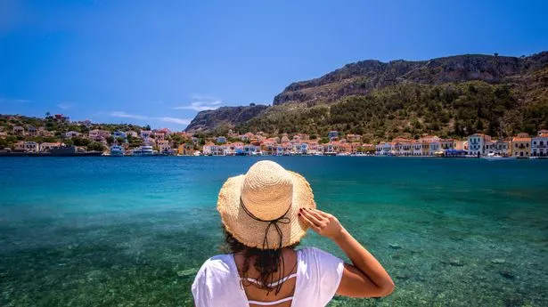 Young woman at shore of Kastellorizo Island, Greece.