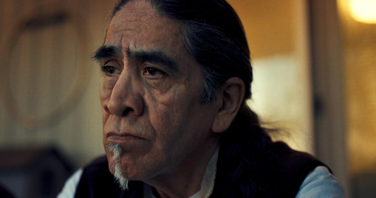 A Native American man weeps in recollection.