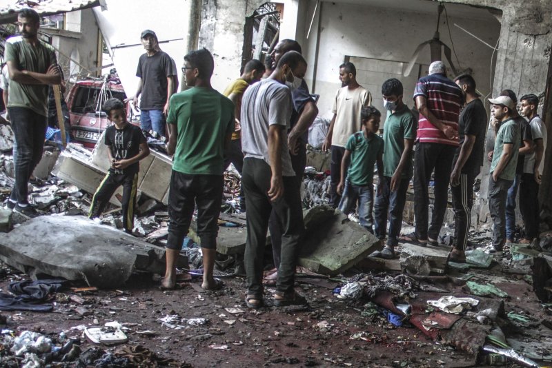 Palestinians in Gaza City search for victims following an Israeli strike that killed more than 100 people in a school sheltering displaced Palestinians on August 10, a medical source said. The United States, Egypt and Qatar offer a cease-fire framework on Friday. Photo by Mahmoud Zaki/UPI