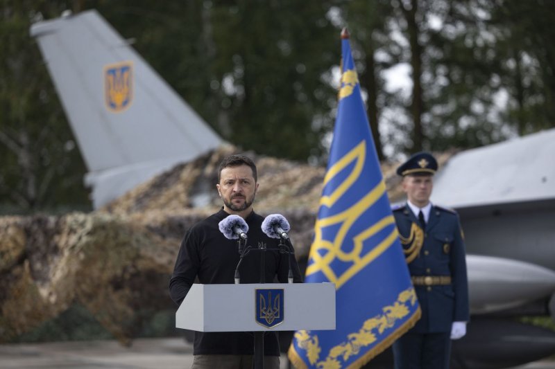 Ukrainian President Volodymyr Zelensky speaks to servicemen next to an American single-engine supersonic multirole fighter F-16 jet during a ceremony at an undisclosed location in Ukraine on Sunday. Zelensky emphasized that the number of F-16 aircraft and trained pilots is still insufficient, as the country waits for additional fighters from partner countries. Photo by Presidential Press Service/EPA-EFE