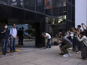 FILE - Chung Pui-kuen, second left, former chief editor and Patrick Lam, left, former acting editor of the now-defunct independent media outlet Stand News leave the court on the last day of the publication's sedition trial closing statements, in Hong Kong, Wednesday, June 28, 2023.