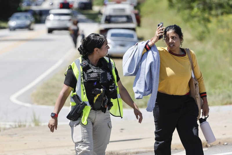 A police officer talks with a woman near the scene of a reported shooting at Apalachee High School in Winder, Ga., on Wednesday. Photo by Erik S. Lesser/EPA-EFE