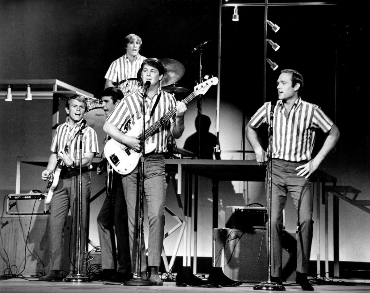 A surf boy band performs at a concert.