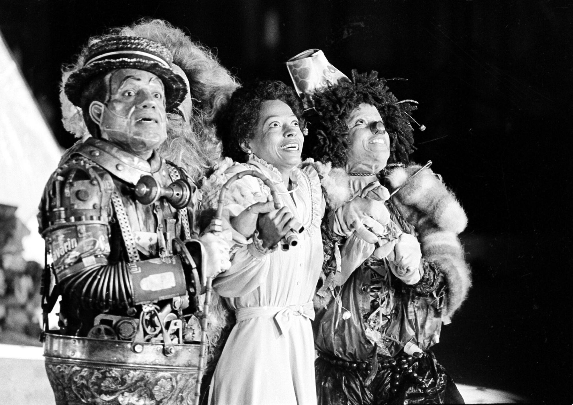 A black and white image of three people performing onstage.