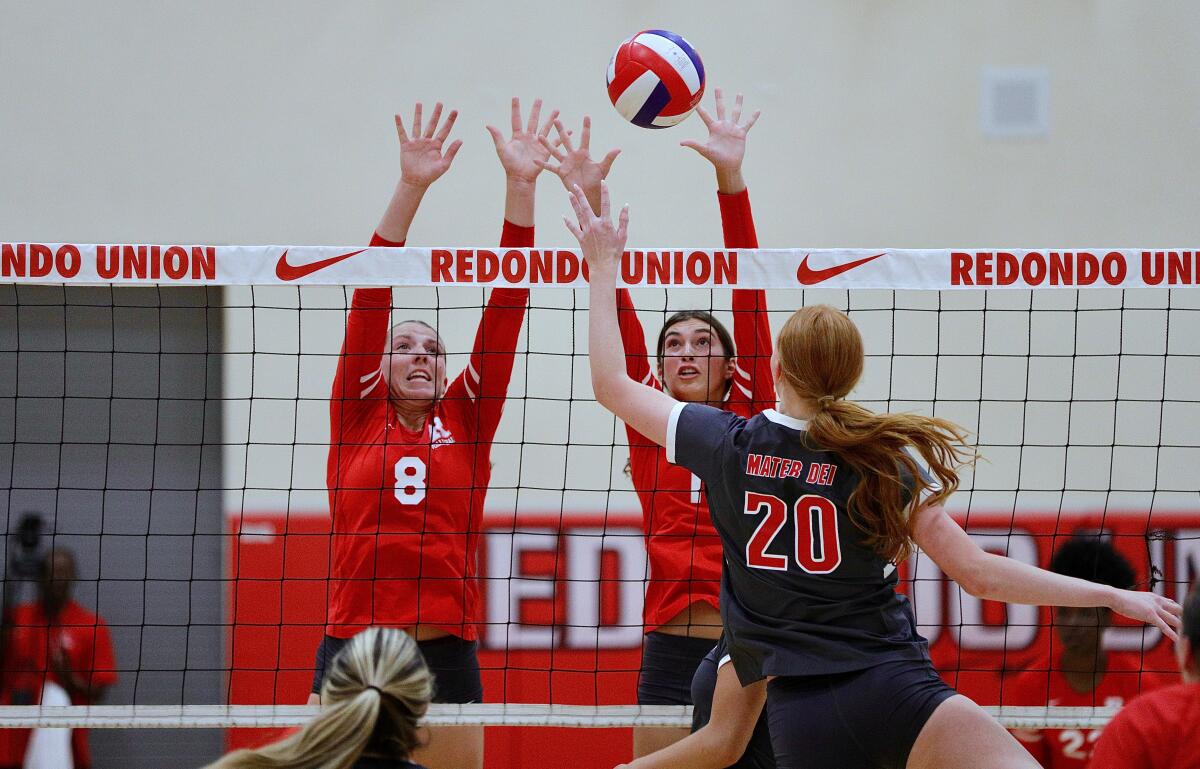 Avery Junk (left) and Sienna Castillo block a tip attempt by Mater Dei's Addison Coady in the Sea Hawks' victory.