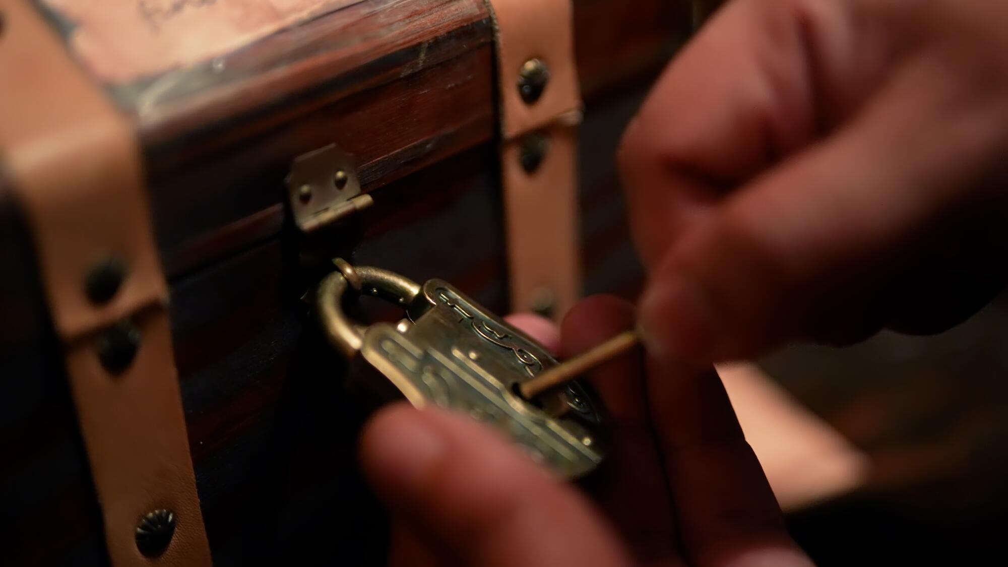 A guest tries to open a mini chest with a lock and key. 