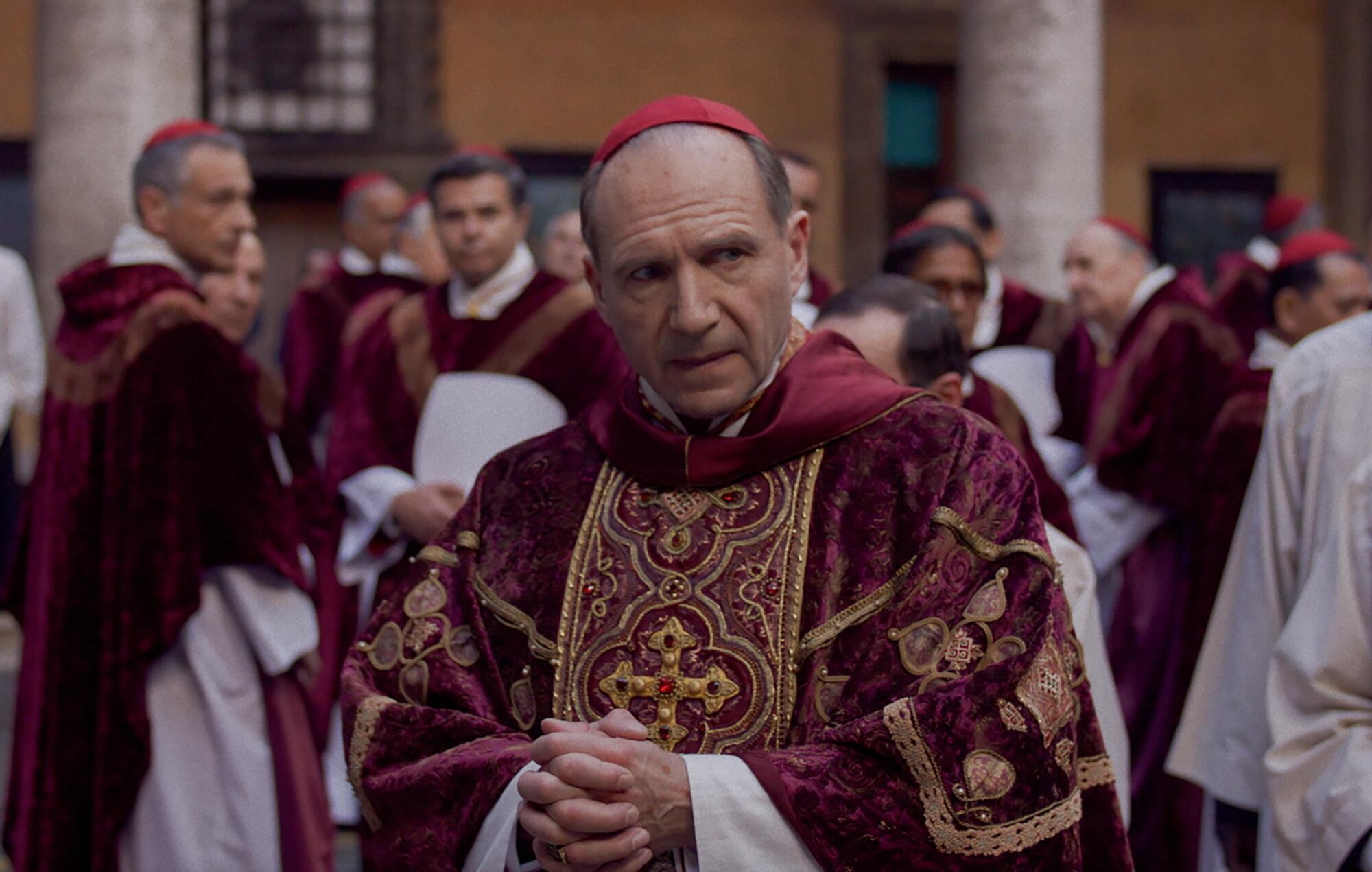 A cardinal in red considers weighty papal matters.