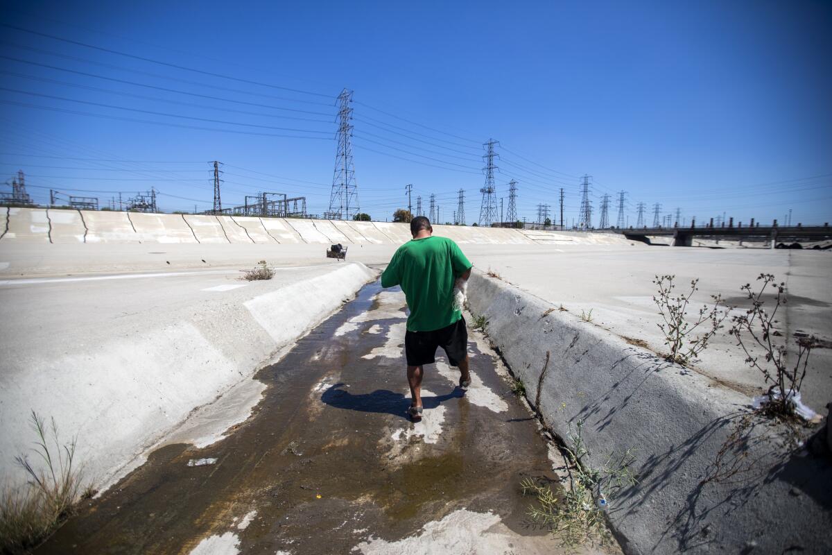  A man stands in a flood control channel.