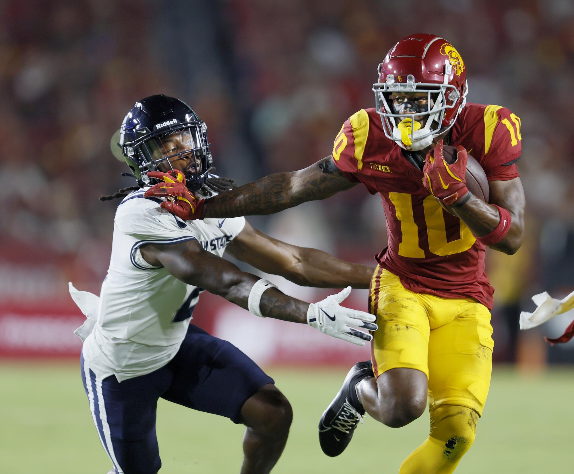 USC wide receiver Kyron Hudson, right, pushes past Utah State cornerback Jaiden Francois.