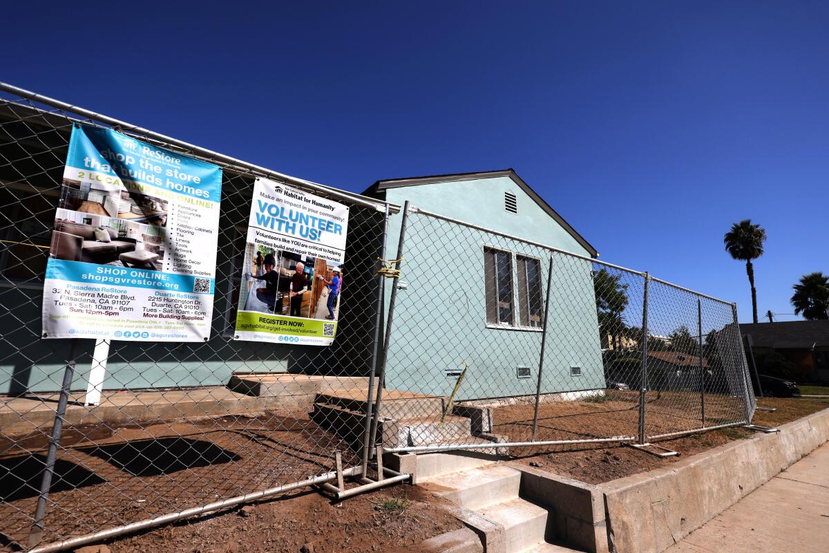 A house behind a chain-link fence.