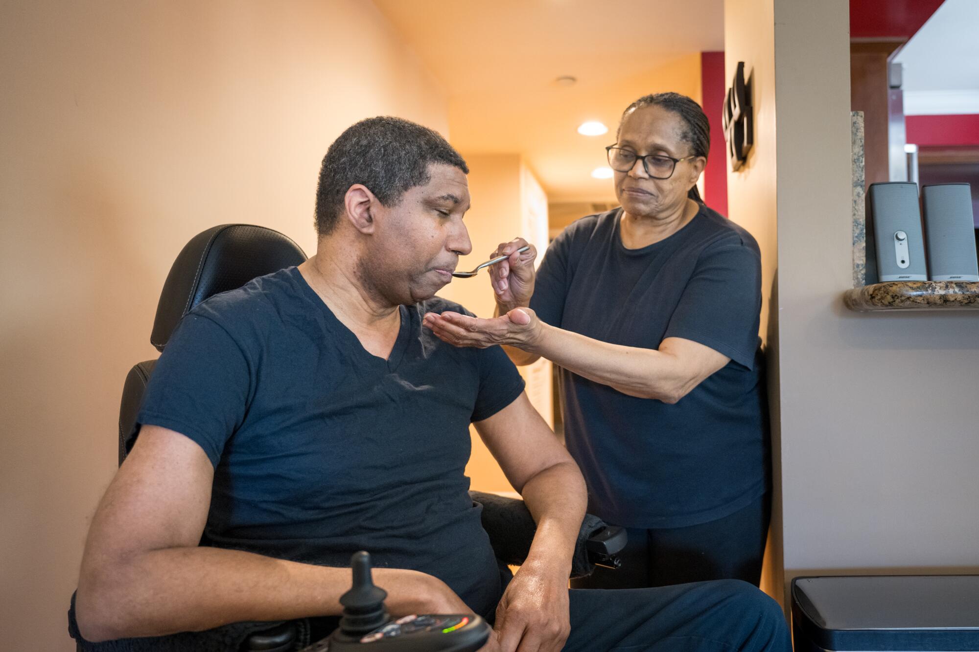 Rita Williamson gives medicine to her brother, former UCLA basketball star Rod Foster in his West L.A. home.