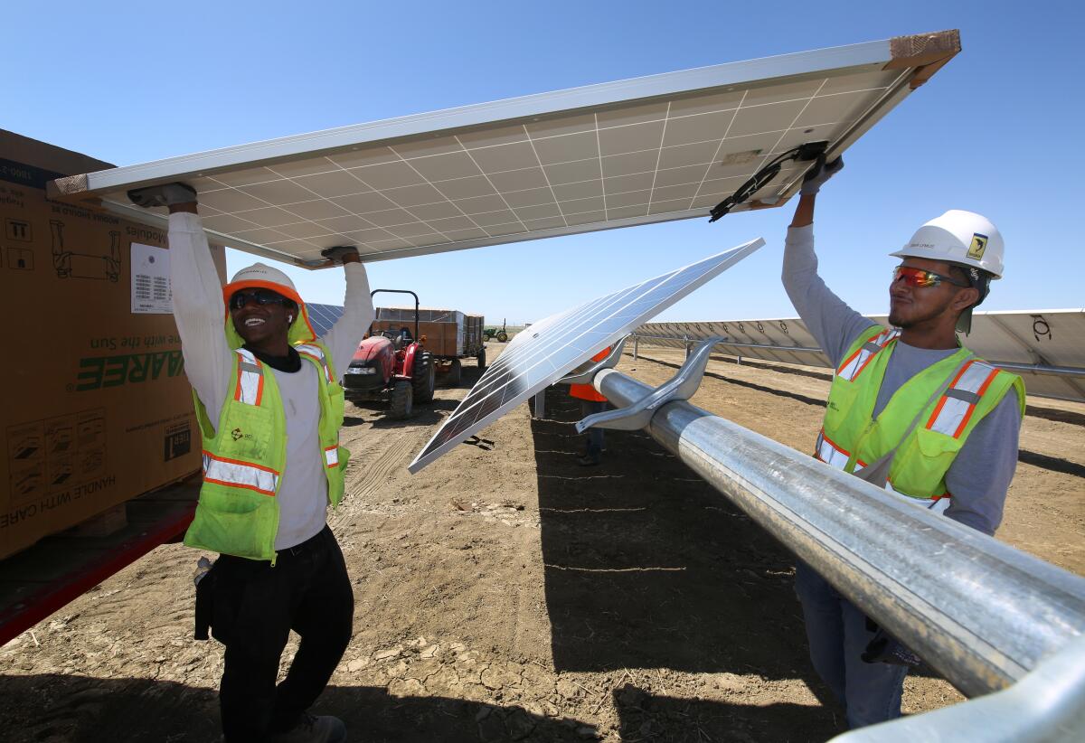 Construction workers install photovoltaic panels at Westlands Solar Park in California's San Joaquin Valley in 2021.