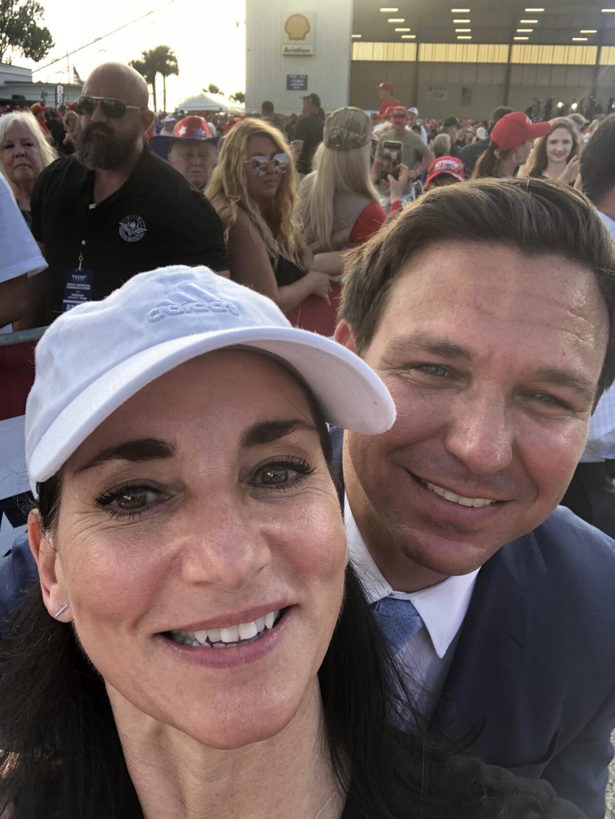 Peggy Hayes takes a selfie with Florida Gov. Ron DeSantis behind her left shoulder