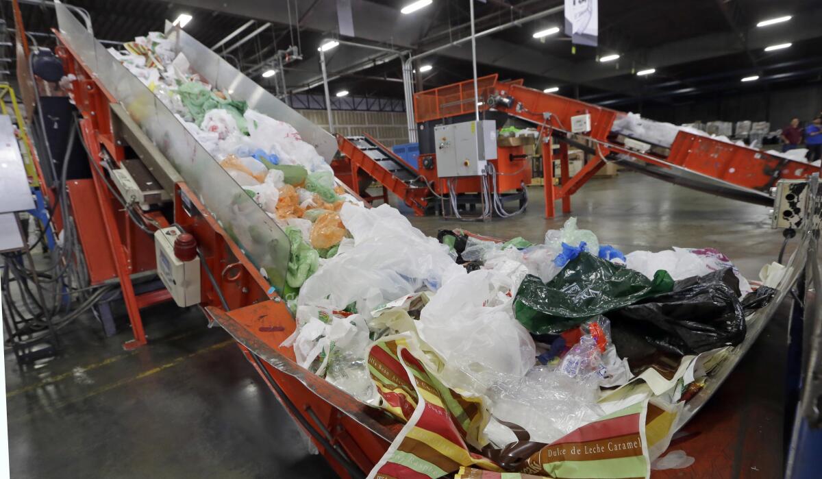 A conveyor belt carries mixed plastic trash