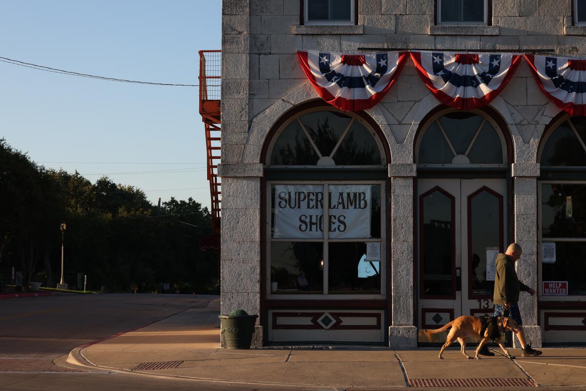 A pedestrian and dog walk through the square in Granbury. 