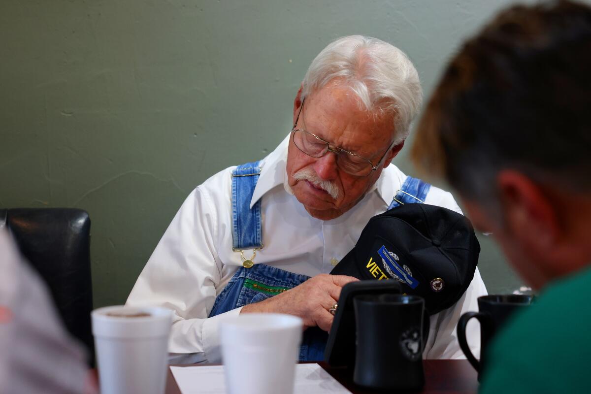 A group of men start Bible study with a prayer, including Bobby Don Shelton, 76, at Paradise Bistro & Coffee Co.