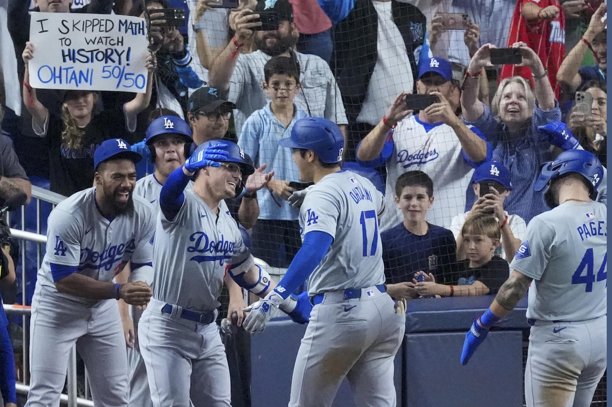 Shohei Ohtani is congratulated by his Dodgers teammates after hitting his 50th home run of the season.