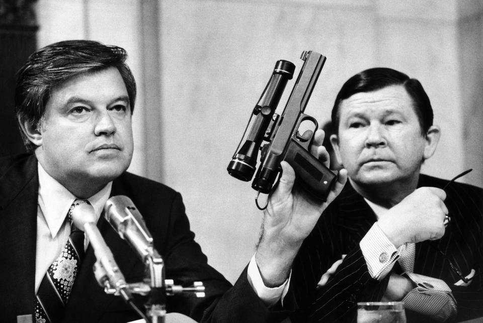 Senator Frank Church holds up the "heart attack gun" at a senate hearing