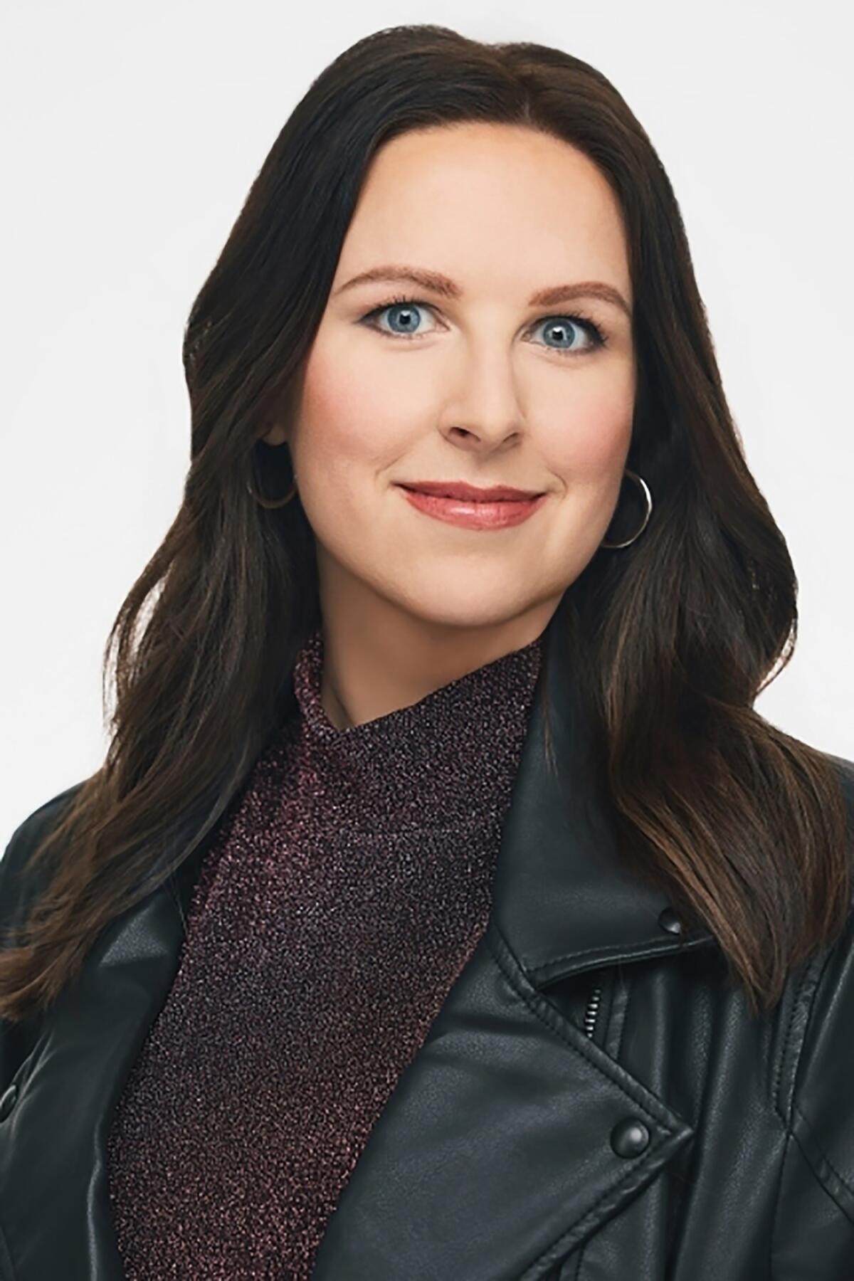 Ashley Spencer, with dark brown hair and a leather jacket, looks into the camera. 