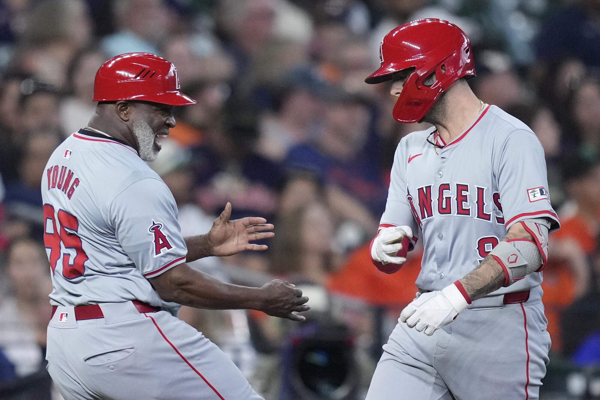 The Angels' Zach Neto is congratulated by third base coach Eric Young Sr. after hitting a solo home run 