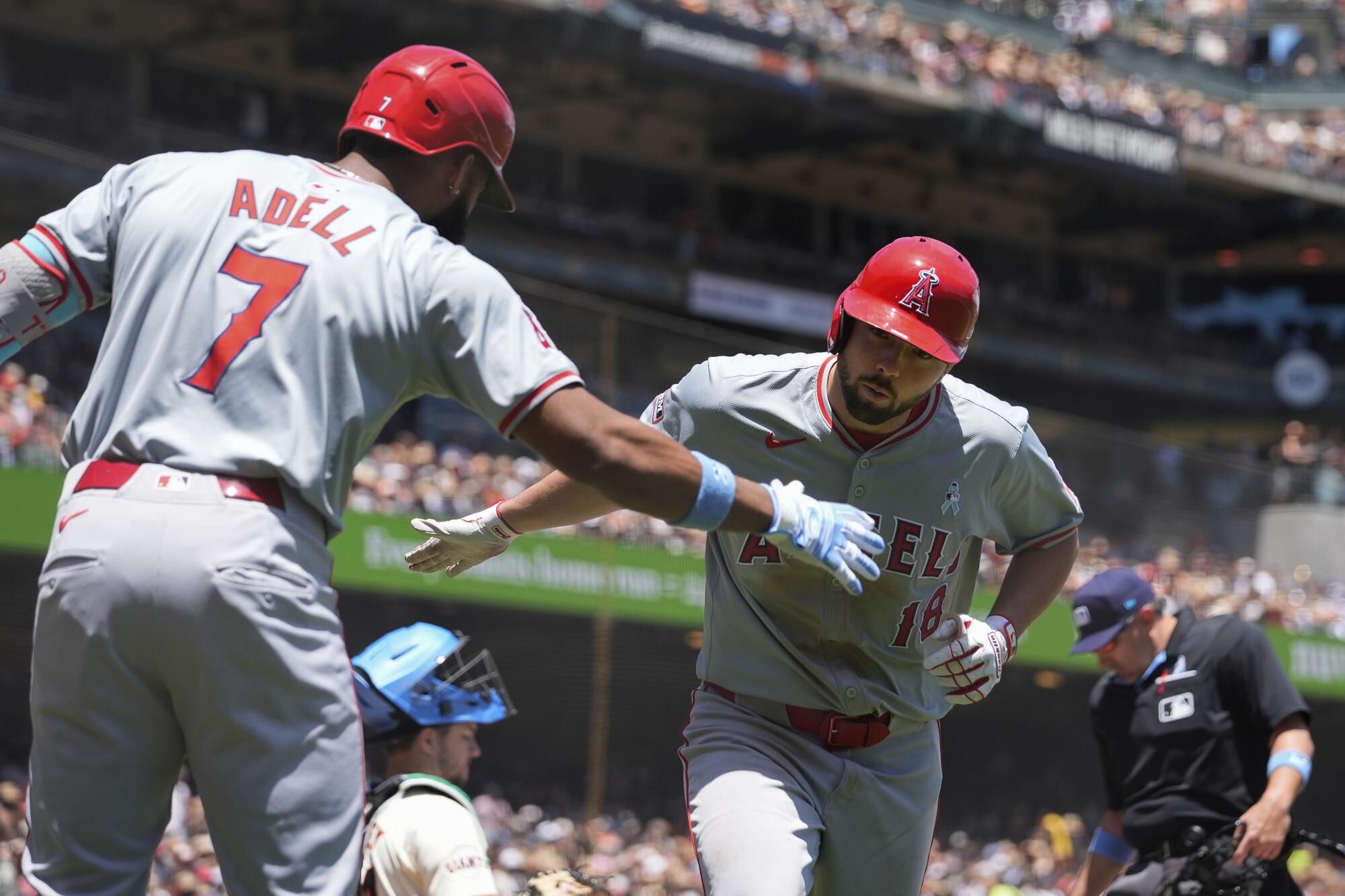 The Angels' Nolan Schanuel high fives Jo Adell after hitting a solo home run.