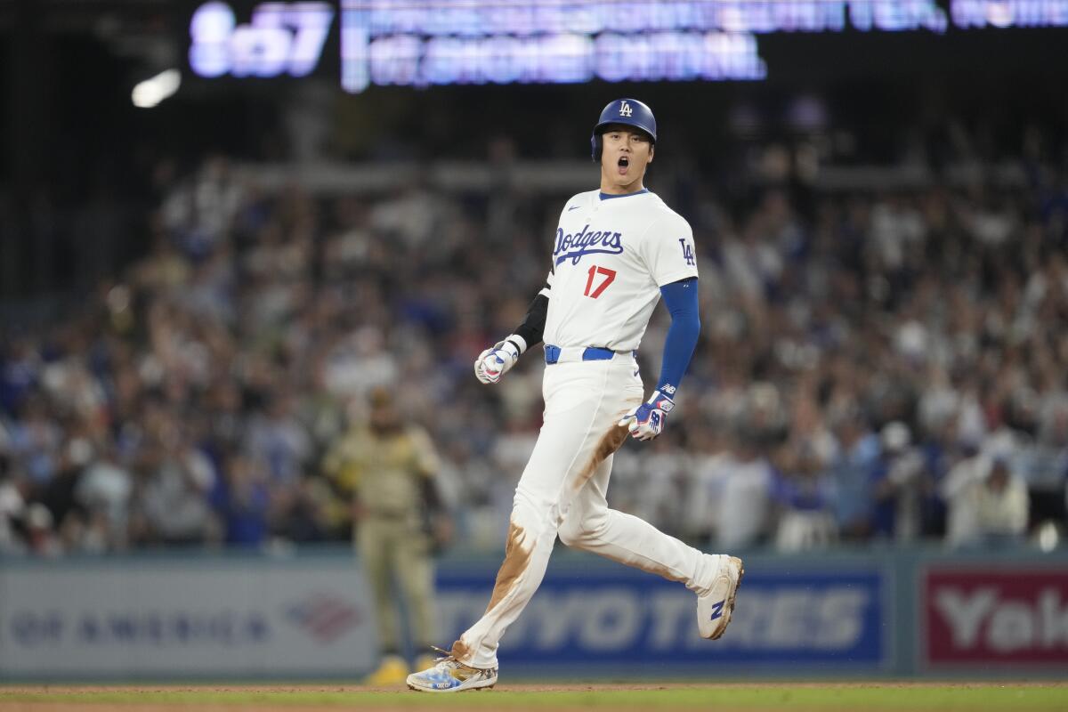 The Dodgers' Shohei Ohtani celebrates after hitting an RBI single and advancing to second off a throwing error 