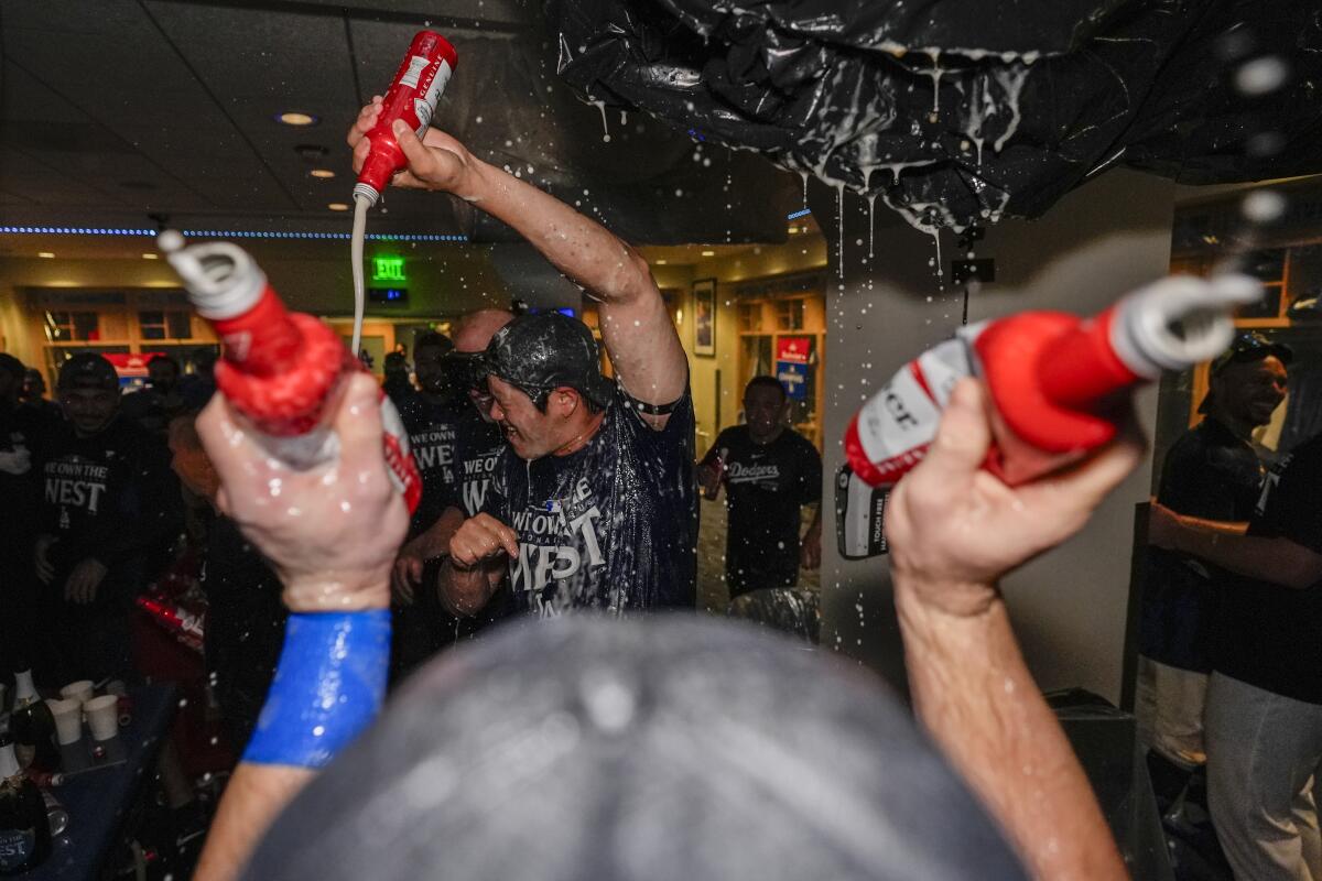 Dodgers designated hitter Shohei Ohtani pours beer in the locker room and celebrates after clinching a division title 