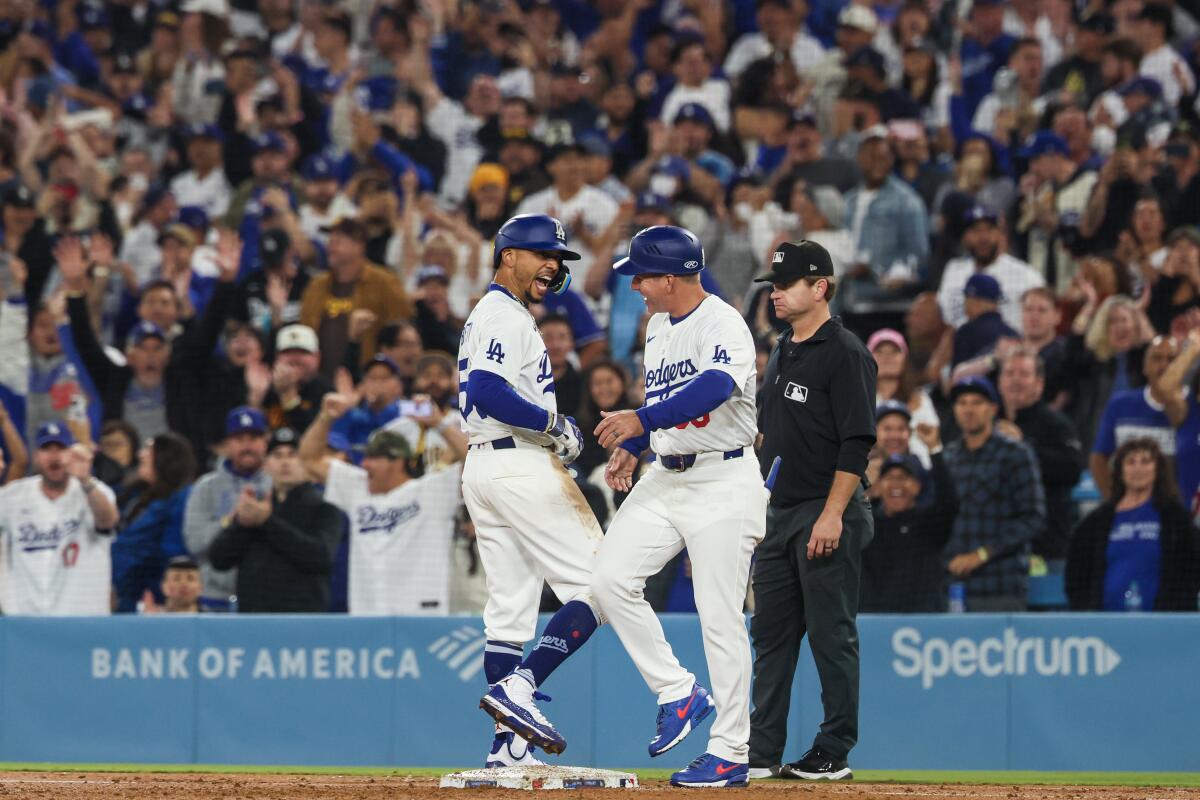 Dodgers shortstop Mookie Betts celebrates with first base coach Clayton McCullough after hitting an RBI single