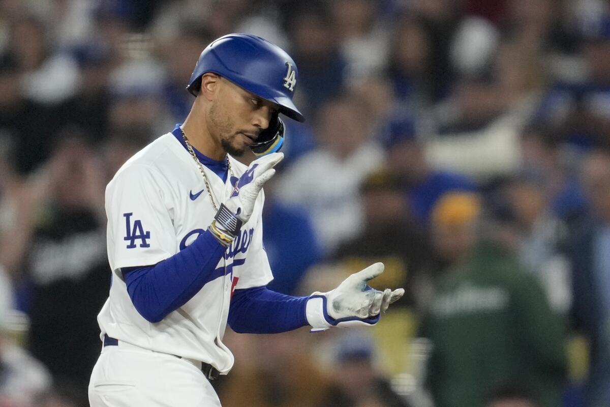 The Dodgers' Mookie Betts celebrates after hitting a single during the first inning of a game against the Padres 